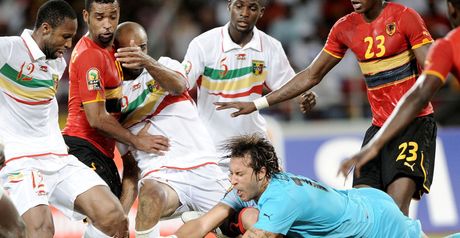 Tight contest: Angola keeper Carlos Fernandes dives for the ball.