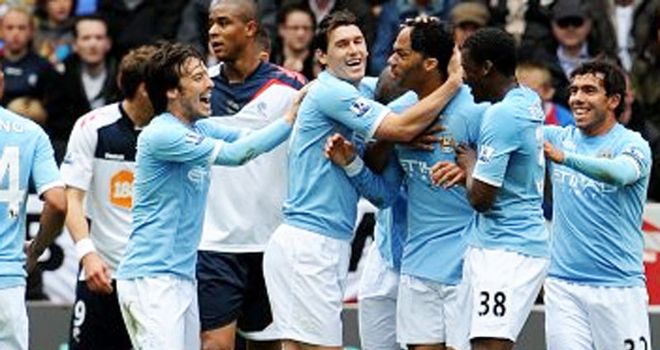 Lescott: Mobbed by team-mates after heading opening City goal