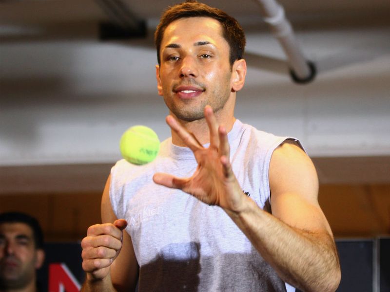 The German, looking relaxed, warms up with the aid of a tennis ball...