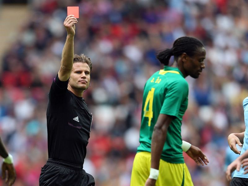 The referee gives Abdoulaye Ba his marching orders after the big centre-half cynically tripped Luis Suarez after the Uruguayan broke through on goal