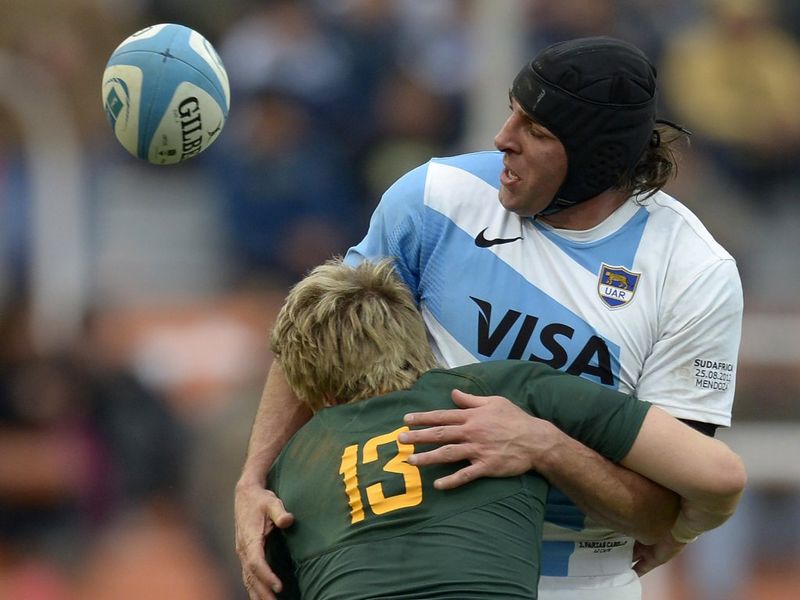 Julio Farias Cabello is wrapped up by Jean de Villiers.