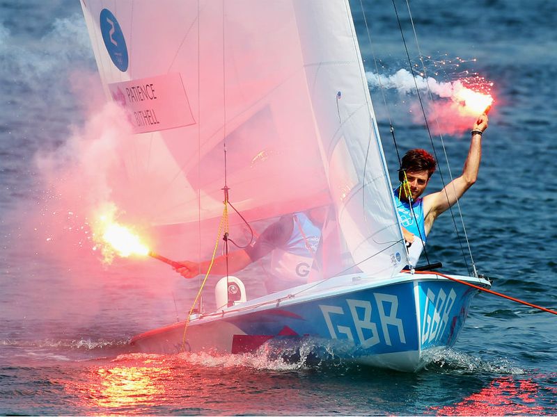 GB's Luke Patience and Stuart Bithell let off flares as they celebrate  winning the silver medal in the men's 470 sailing class.