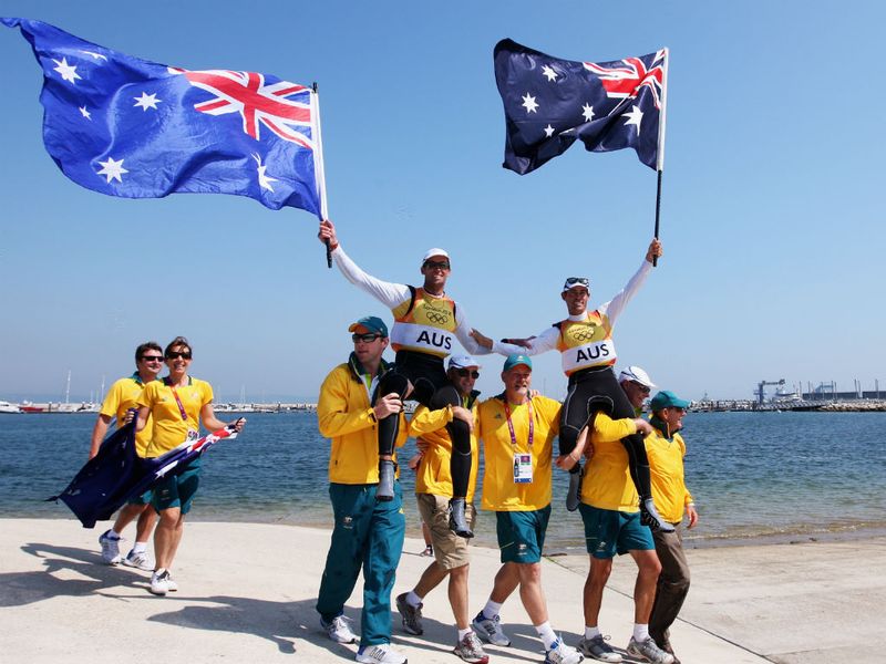 Australian sailors Mathew Belcher and Malcolm Page are welcomed onshore by team mates after winning gold in the men's 470 sailing.