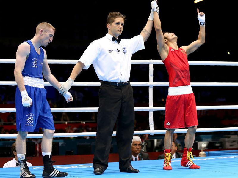 Joy and despair: Zou Shiming of China is declared the winner over Ireland's Paddy Barnes during their light fly (49kg) boxing semi-final.