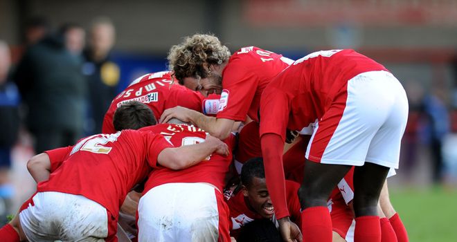 Adams: Mobbed by his team-mates after hitting late winner
