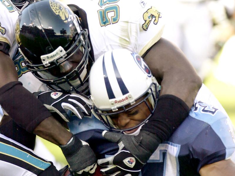 Tennesse running back Eddie George is wrapped up by Wali Rainer as his Jaguars record a 24-19 victory