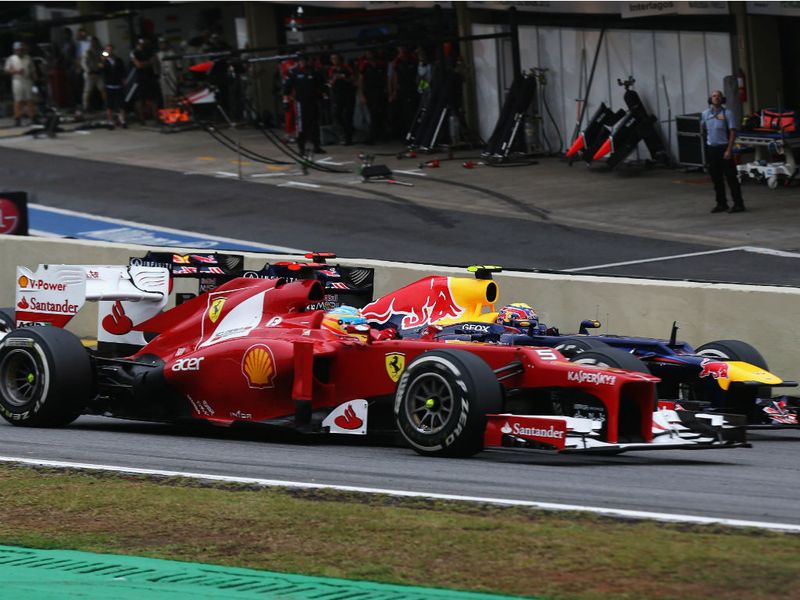 Fernando Alonso goes around the outside of Mark Webber