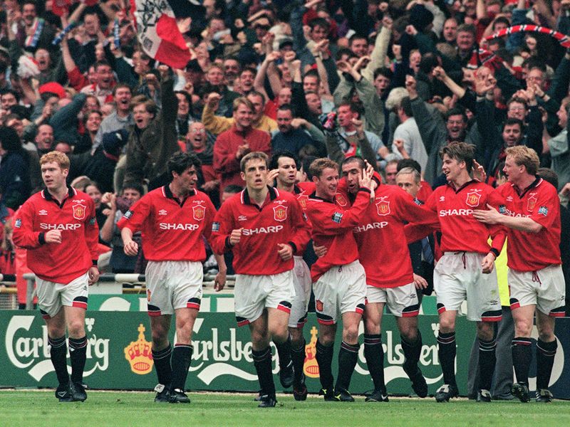 Cantona is mobbed after scoring the only goal in the 1996 FA Cup final against Liverpool