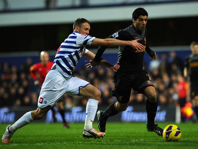 Luis Suarez slides past Clint Hill