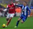 Alex Oxlade-Chamberlain (left) holds off Wigan's James McCarthy