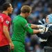 Joe Hart prevents a City fan from confronting Rio Ferdinand, who was struck by something thrown from the crowd