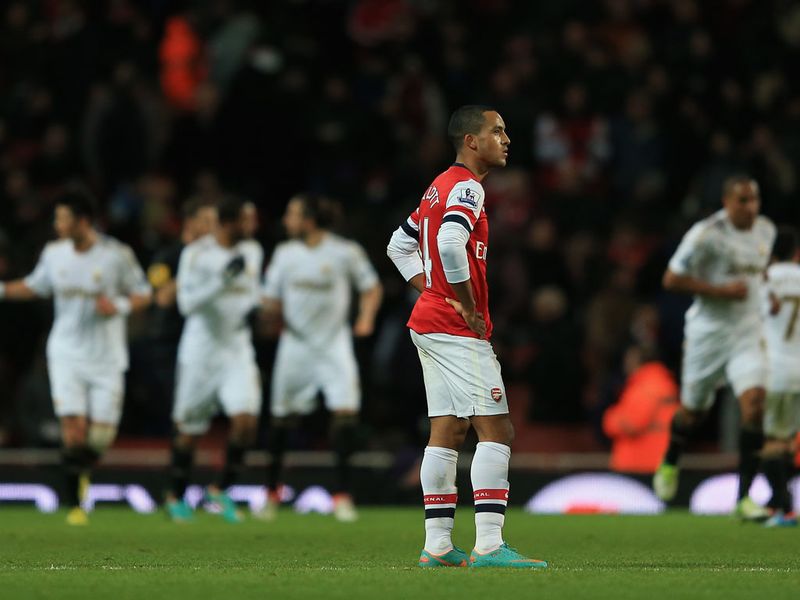 Theo Walcott's disappointment is clear to see as Swansea celebrated during a 2-0 victory at Arsenal