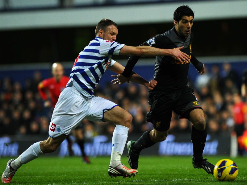 Liverpool's Luis Suarez runs past Clint Hill of QPR on his way to scoring the opening goal at Loftus Road.