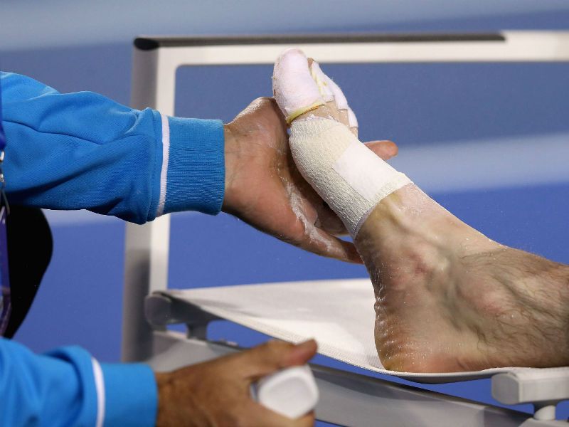 Trouble afoot: Murray receives medical attention to his foot after losing the second set