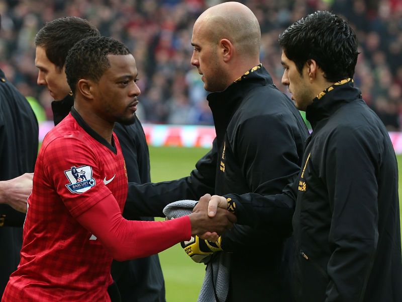 New start: Patrice Evra of Manchester United shakes hands with Liverpool's Luis Suarez ahead of the clash at Old Trafford
