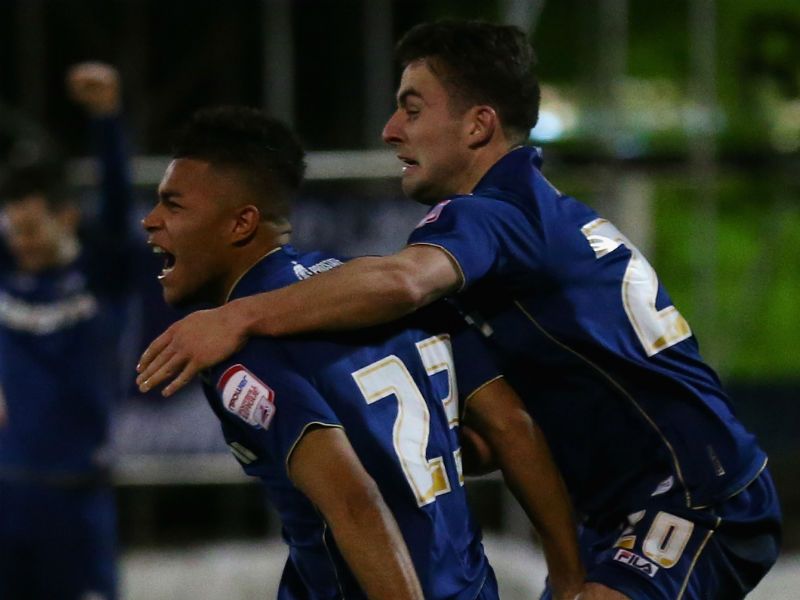 Sensing victory: Reece Wabara (left) celebrates scoring Oldham's third goal with team-mate Jose Baxter. Joe Allen pulled one back but the Latics held on