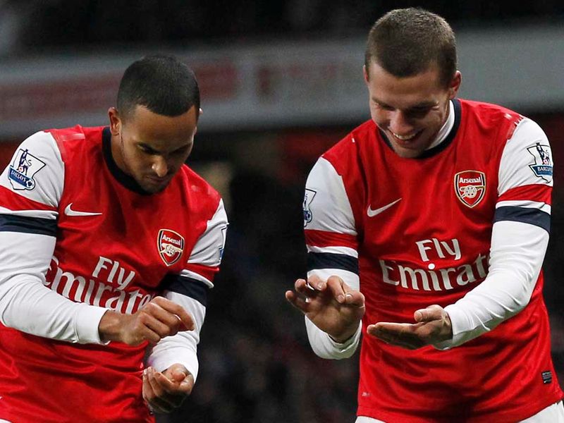 Walcott and Podolski react to the former's strike as he puts Arsenal 4-1 ahead.