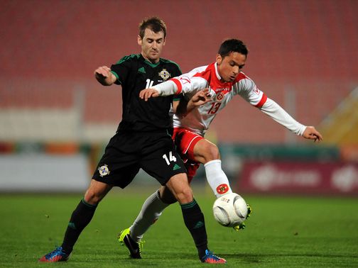 Niall McGinn and Andre Schembri battle for the ball