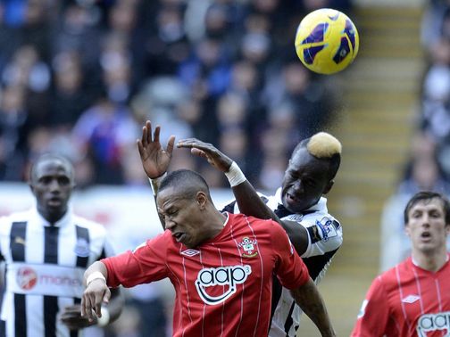 Cheick Tiote jumps for the ball with Nathaniel Clyne