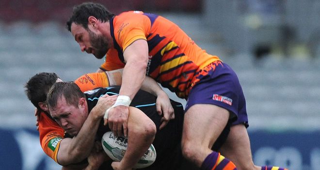 The Widnes defence wraps up Broncos' Scott Wheeldon