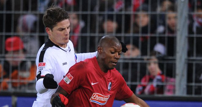 Freiburg's Karim Guede holds off Pirmin Schwegler