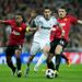 Angel Di Maria is challenged by Manchester United duo Patrice Evra and Michael Carrick