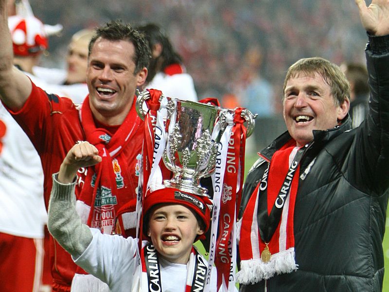Carragher celebrates with his son again and Kenny Dalglish after last season's Carling Cup victory over Cardiff