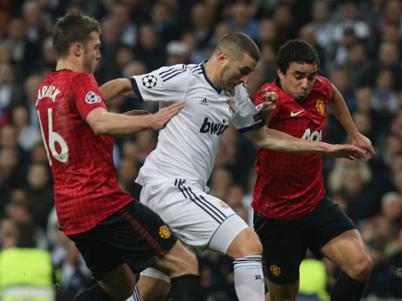 Manchester United pair Michael Carrick and Rafael try to halt Real Madrid striker Karim Benzema