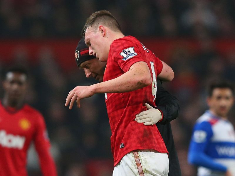 Phil Jones is helped off the pitch after suffering an injury during a collision with Mariappa.