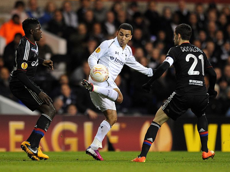 Tottenham winger Aaron Lennon fends off the advances of two Lyon players