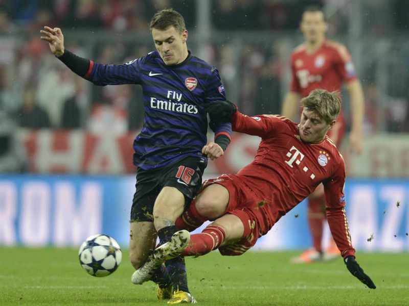 Bayern Munich midfielder Toni Kroos dives in on Arsenal counterpart Aaron Ramsey