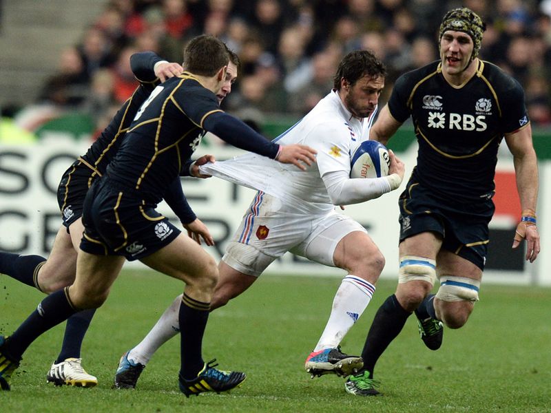 Tugged back: France's left wing Maxime Medard tries to break through