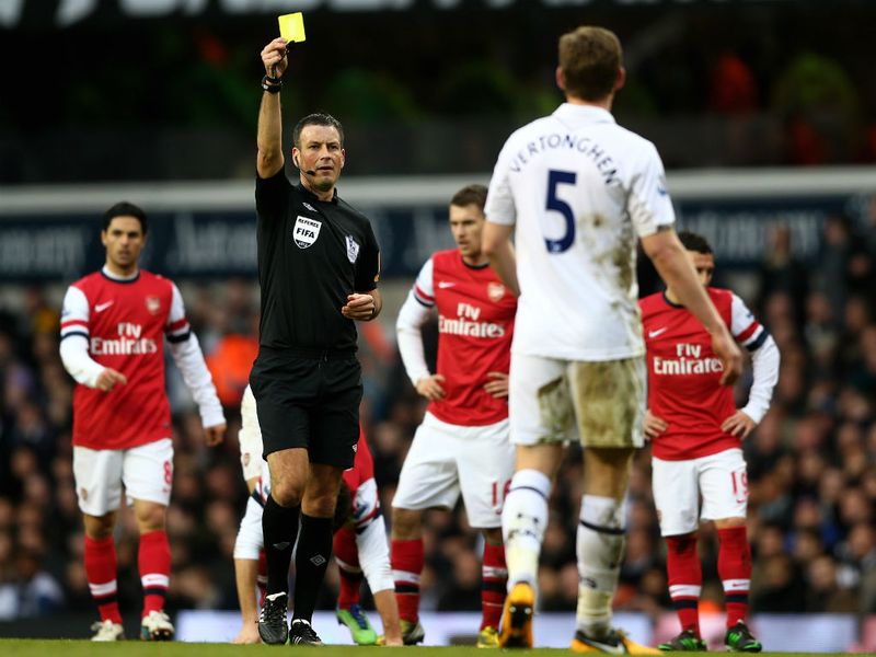 Referee Mark Clattenburg shows the yellow card to the Belgian defender