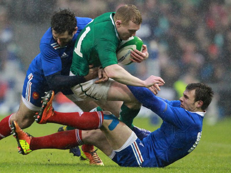 Giving their all: Keith Earls is tackled by France's Vincent Clerc and Yoann Huget