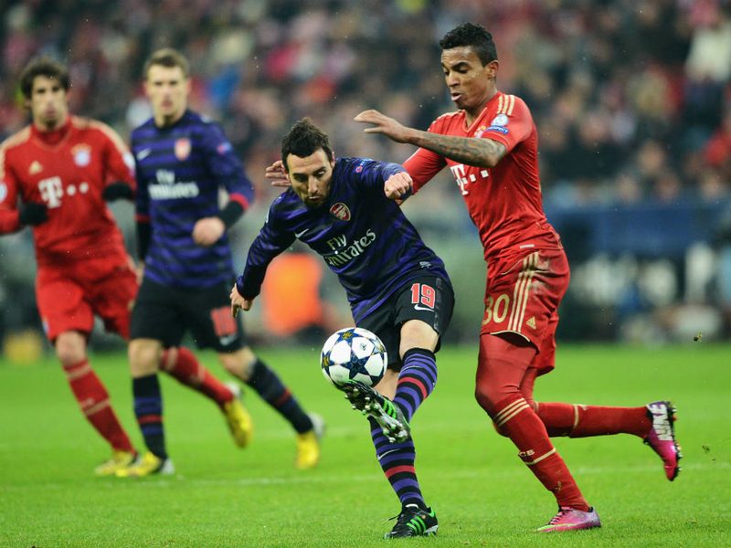 Arsenal playmaker Santi Cazorla tries to escape the attentions of Bayern Munich midfielder Luiz Gustavo