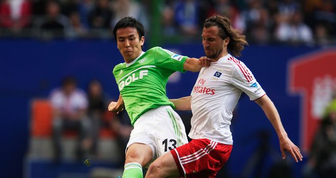 Petr Jiracek of Hamburg and Makoto Hasebe of Wolfsburg battle for the ball