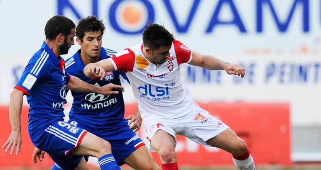 Nancy midfielder Thomas Mangani holds off the challenge from his Lyon opponents
