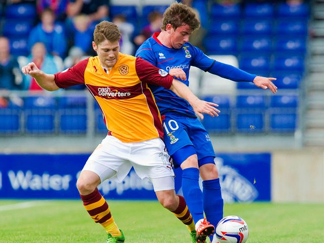 Iain Vigurs battles for the ball with Aaron Doran