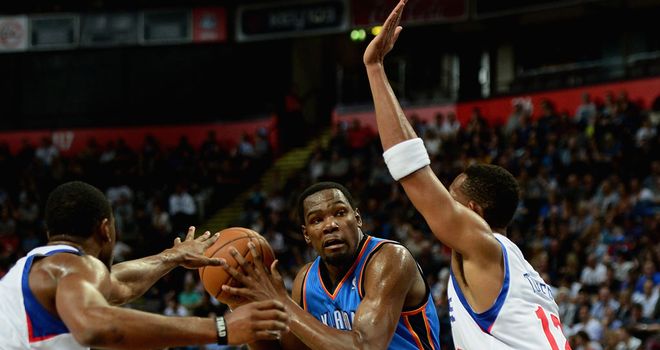 Kevin Durant (in blue) on the charge in Manchester