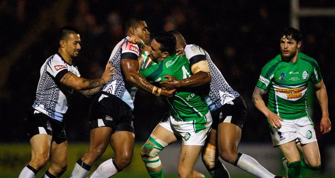 Apirana Pewhairangi of Ireland is tackled by Fiji's Kevin Naiqama and Waisale Ligani Naiqama