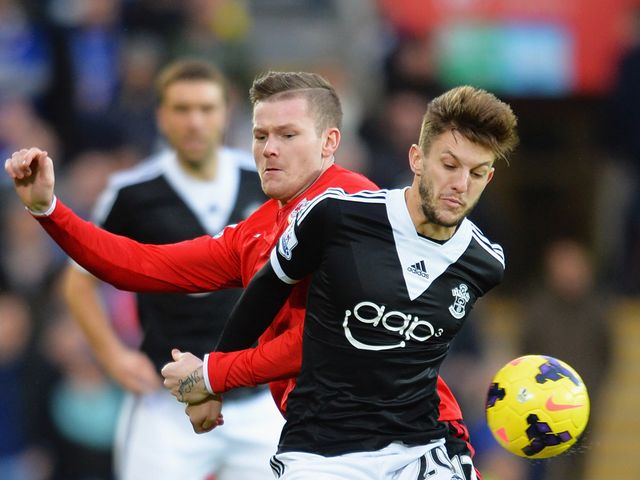 Adam Lallana holds off Aron Gunnarsson