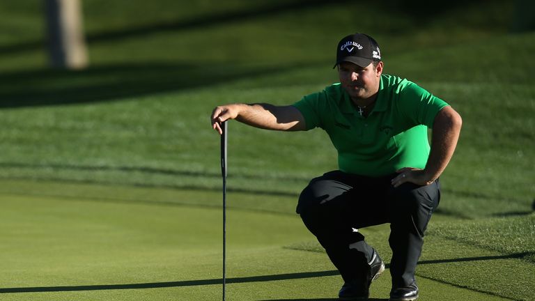 Patrick Reed lines up a putt on the ninth hole