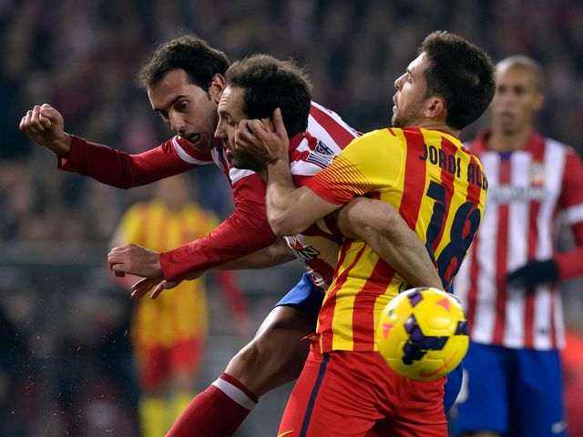 Atletico Madrid's Diego Godin vies with Jordi Alba