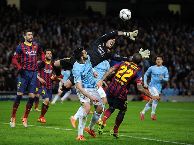 Barcelona goalkeeper Victor Valdes reaches for the ball