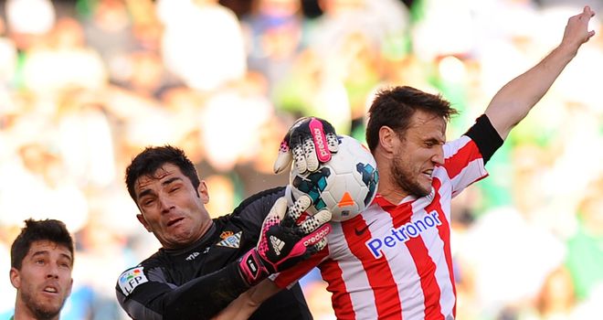 Real Betis goalkeeper Adan just about gathers the ball
