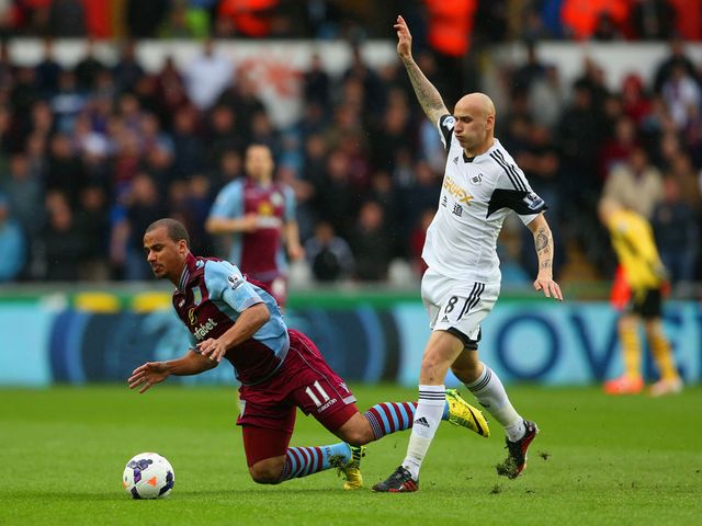 Gabriel Agbonlahor of Aston Villa clashes with Jonjo Shelvey of Swansea