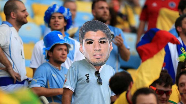 A Uruguay fan wears a Luis Suarez mask during the game against Colombia