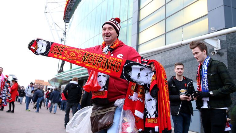 A street trader sells Jose Mourinho Manchester United scarves before the match