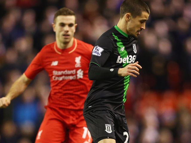 Bojan Krkic of Stoke City is watched by Liverpool captain Jordan Henderson  