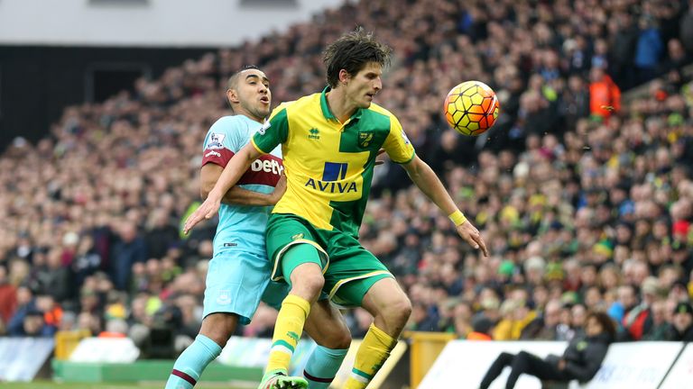 Norwich City's Timm Klose tussles with West Ham United's Dimitri Payet